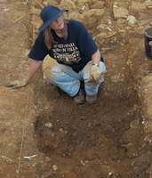 Ruth in trench with trowel