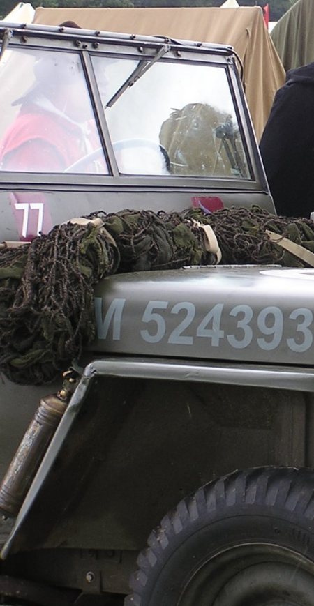 Picture of jeep with soldier in red uniform seen through windscreen